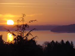 Sun setting behind Point Defiance and Gig Harbor, WA.
